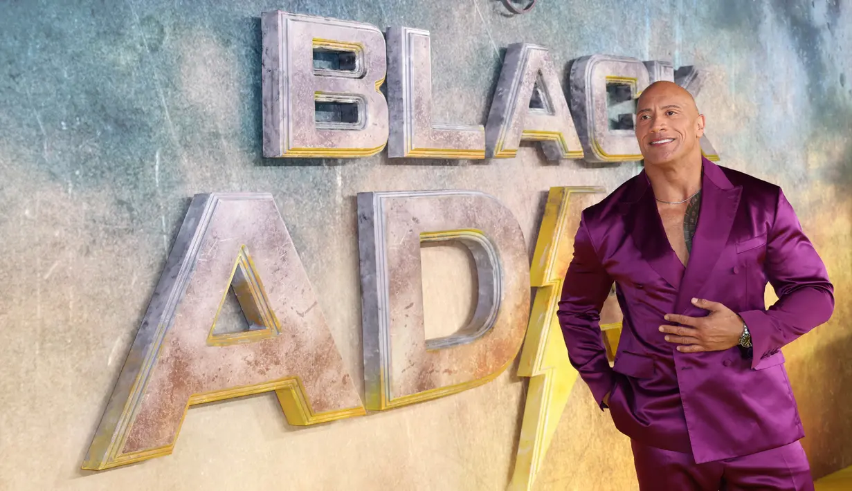 Dwayne Johnson berpose untuk fotografer saat tiba pada pemutaran perdana film 'Black Adam' di London, Inggris, 18 Oktober 2022. Dwayne Johnson atau The Rock tampil memukau saat menghadiri acara tersebut. (Photo by Vianney Le Caer/Invision/AP)