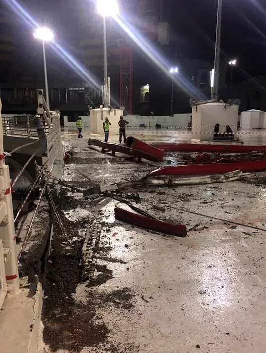 Sejumlah petugas berkumpul di dekat kerusakan yang disebabkan jatuhnya alat berat proyek (crane) di Masjidil Haram, Mekkah, Jumat (11/9/2015). Sebanyak 107 orang dilaporkan tewas, termasuk warga negara Indonesia. (AFP PHOTO / STR)