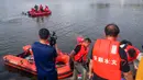 Tim penyelamat mencari korban selamat dari sebuah bus yang jatuh ke danau di Anshun, provinsi Guizhou, China, Selasa (7/7/2020). Sedikitnya 21 orang tewas usai bus yang membawa siswa untuk mengikuti ujian masuk perguruan tinggi atau gaokao itu menabrak pagar pembatas lalu tercebur ke danau (STR/AFP)