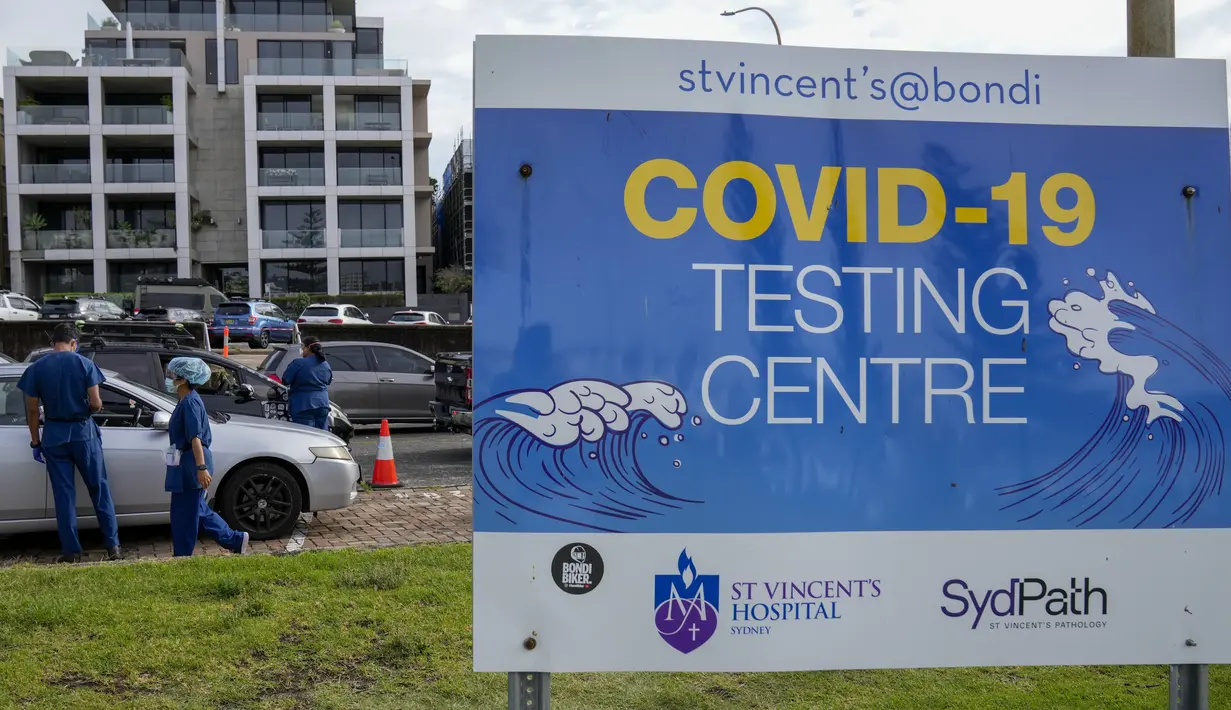 Staf memeriksa klien di klinik pengujian COVID-19 drive-thru di Pantai Bondi di Sydney, Sabtu (8/1/2022). Negara bagian terpadat di Australia itu memberlakukan kembali beberapa pembatasan dan menangguhkan operasi elektif ketika kasus COVID-19 melonjak ke rekor baru lainnya. (AP Photo/Mark Baker)