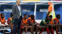 Pelatih Kamerun, Volker Finke (berdiri) menyaksikan anak asuhnya berlaga di penyisihan Piala Dunia 2014 Grup A melawan Tim Samba di Stadion Nasional Brasil, (24/6/2014). (REUTERS/Michael Dalder)