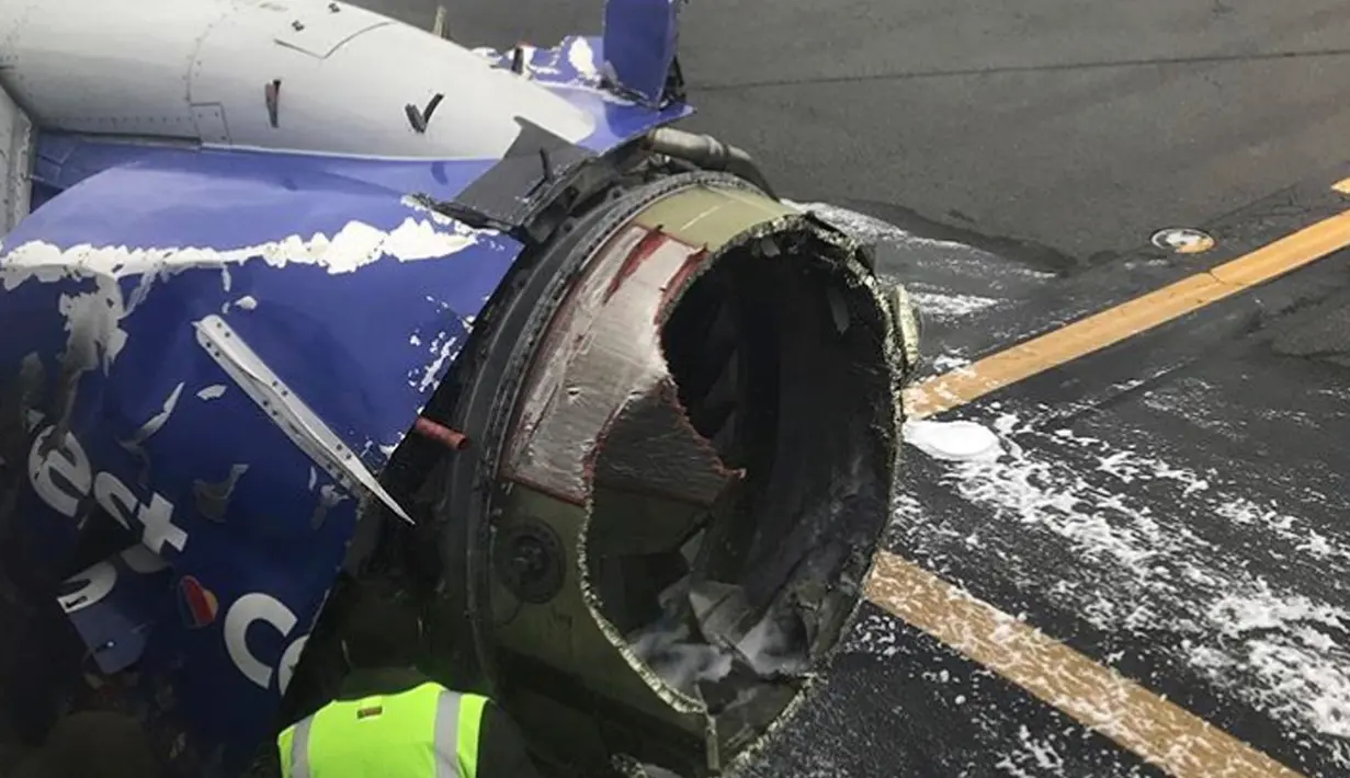 Petugas memeriksa kerusakan mesin pesawat yang membuat pesawat Southwest Airlines mendarat darurat di Philadelpia, Amerika Serikat, Selasa (17/4). Pesawat terbang selama 10 menit dengan satu mesin sebelum akhirnya mendarat darurat. (Amanda Bourman via AP)