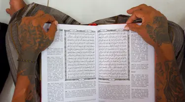 Tangan seorang napi terlihat saat membacakan mushaf Al Quran di sebuah penjara di Serang, Jawa Barat pada 27 Maret 2023. (AFP/Dziki Oktomauliyadi)