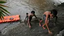 Sejumlah anak tampak menaiki tebing saat bermain di aliran Sungai Ciliwung, Jakarta, Rabu (18/5/2016). Air Ciliwung yang mulai membersih dimanfaatkan anak-anak sekitar Cikiwung untuk berenang. (Liputan6.com/Yoppy Renato)