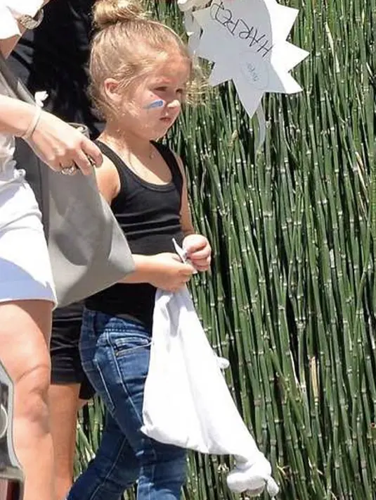 Harper Beckham mengenakan tampil casual dengan kaos hitam tanpa lengan dan celana jeans (harperbeckhamfashion)