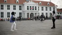 Warga berpose untuk difoto di kawasan wisata Kota Tua, Jakarta, Senin (23/1/2022). Kawasan wisata Kota Tua yang saat ini terbebas dari pedagang kaki lima (PKL) masih menjadi alternatif warga untuk mengisi liburan, termasuk cuti bersama menyambut perayaan Tahun Baru Imle 2023. (Liputan6.com/Faizal Fanani)