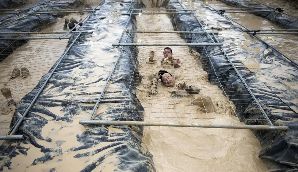 Para peserta tampak berenang di kolam lumpur pada acara Hari Lumpur di Beynes, Prancis (10/5/14). (AFP Photo/Martin Bureau)