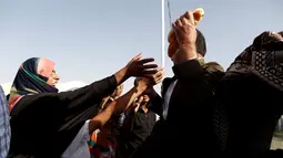 Seorang warga berebut sepotong roti saat mengungsi di kamp Khazer, Irak, (11/11). Mereka terpaksa melarikan diri dari kampung halamannya saat Pasukan Irak dan kelompok militan ISIS bentrok. (REUTERS/Zohra Bensemra)