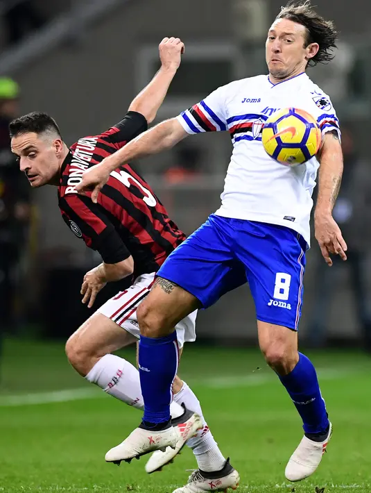Gelandang AC Milan, Giacomo Bonaventura berebut bola dengan pemain Sampdoria, Edgar Osvaldo Barreto dalam lanjutan pertandingan Serie A di San Siro, Minggu (18/2). AC Milan menundukkan tamunya Sampdoria dengan skor tipis 1-0. (MIGUEL MEDINA / AFP)
