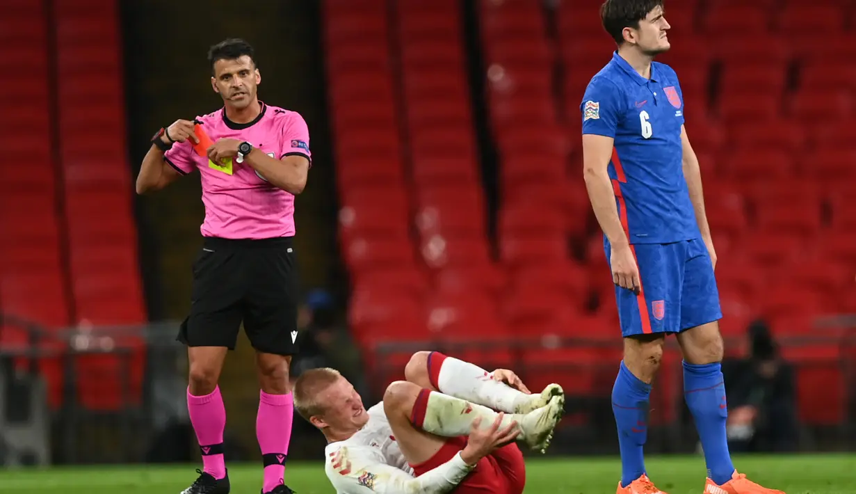 Wasit Jesús Gil Manzano (Kiri) menarik kartu merah untuk bek Inggris, Harry Maguire setelah menjegal penyerang Denmark, Kasper Dolberg dalam lanjutan pertandingan UEFA Nations League grup A2 di stadion Wembley di London (14/10/2020). Inggris takluk atas Denmark 0-1. (AFP/Pool/Daniel Leal-Olivas)