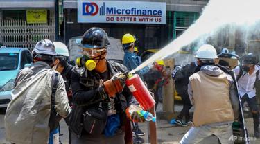 Pengunjuk rasa anti-kudeta mengeluarkan alat pemadam kebakaran untuk melawan dampak gas air mata yang ditembakkan oleh polisi selama demonstrasi di Yangon, Myanmar, pada 4 Maret 2021.