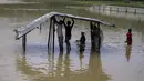 Pengungsi memperbaiki tempat penampungan yang rusak akibat hujan deras di kamp pengungsi Rohingya di Kutupalong, Bangladesh (28/7/2021). Hujan deras berhari-hari telah membuat ribuan tempat penampungan di berbagai kamp pengungsi Rohingya di Bangladesh Selatan terendam air. (AP Photo/Syafiqur Rahman)