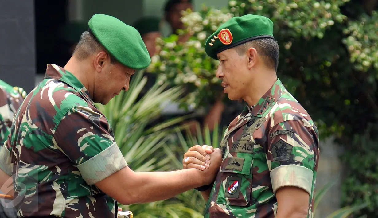Letjen TNI Agus Sutomo (kanan) bersalaman dengan Mayjen Teddy Lhaksmana WK saat Apel Bersama Satuan Jajaran Kodam Jaya di Makodam Jaya, Jakarta, Kamis (17/9/2015). Apel diiringi serah terima jabatan Pangdam Jaya. (Liputan6.com/Helmi Fithriansyah)
