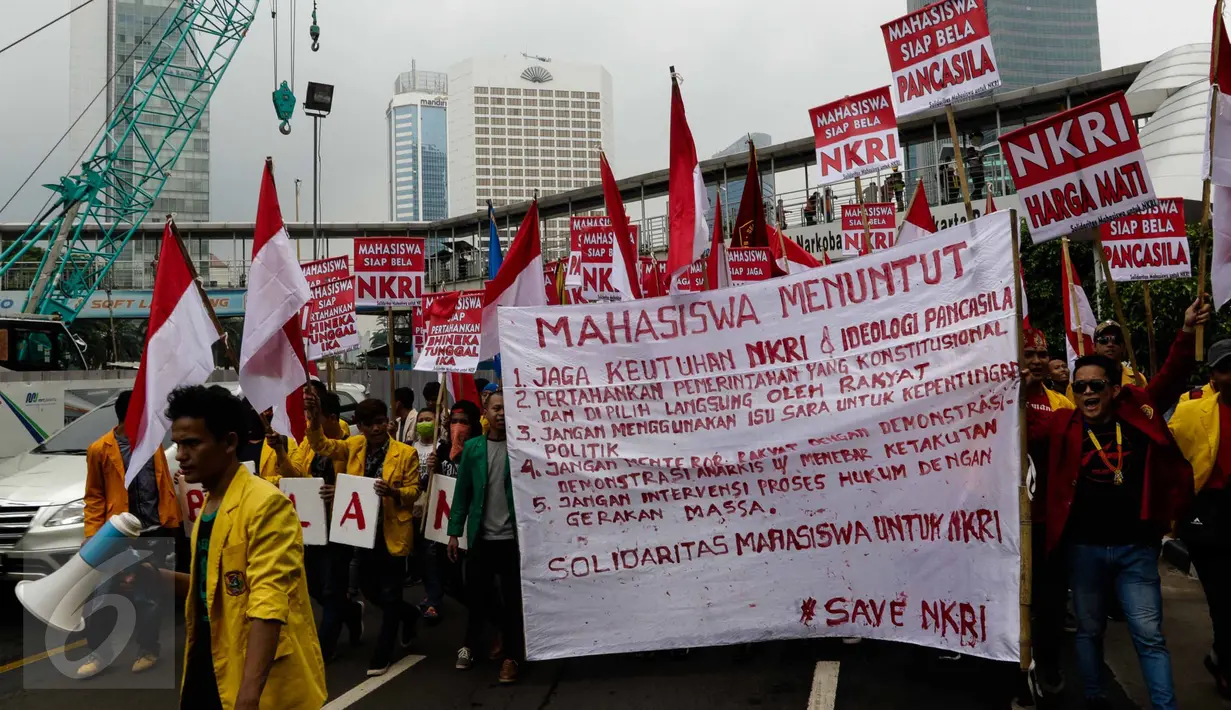 Mahasiswa membentangkan spanduk saat melakukan longmarch dari Bundaran HI menuju Istana, Jakarta, Senin (21/11). Mereka menyatakan sikap untuk menjaga keutuhan NKRI dan Ideologi Pancasila. (Liputan6.com/Faizal Fanani)