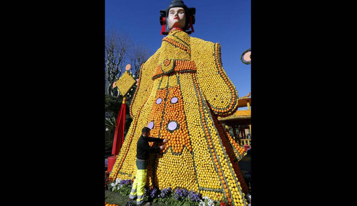 Sejumlah orang bekerja membangun patung yang terbuat dari jeruk dan lemon menjelang festival Lemon di Menton, sebuah kota kecil di Perancis, Rabu (12/2/2015). (AFP PHOTO/Valery Hache)