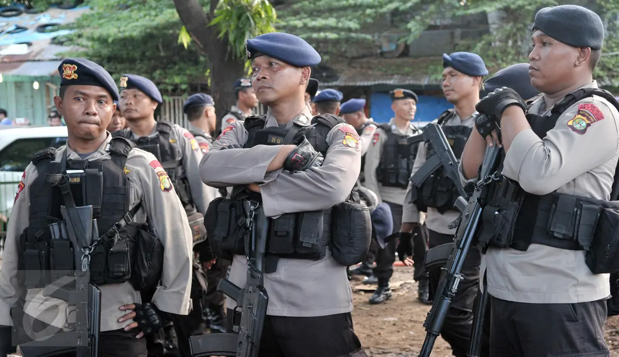Petugas berjaga-jaga di sekitar lokasi ditemukannya senjata tajam dan alat narkoba di kawasan Manggarai, Jakarta Selatan, Rabu (8/3). (Liputan6.com/Yoppy Renato)