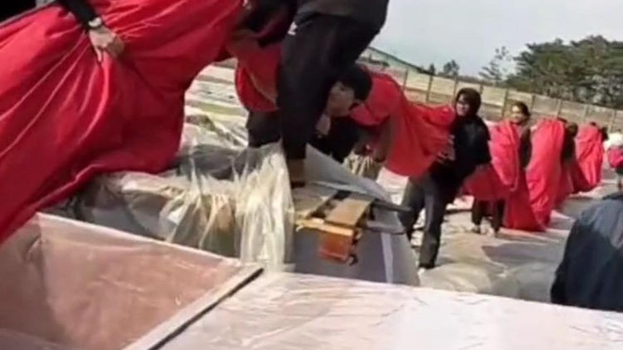 Dengan berat bendera hampir 1 ton, bendera ini pun harus digotong banyak orang untuk memasukkannya ke dalam kotak kayu.