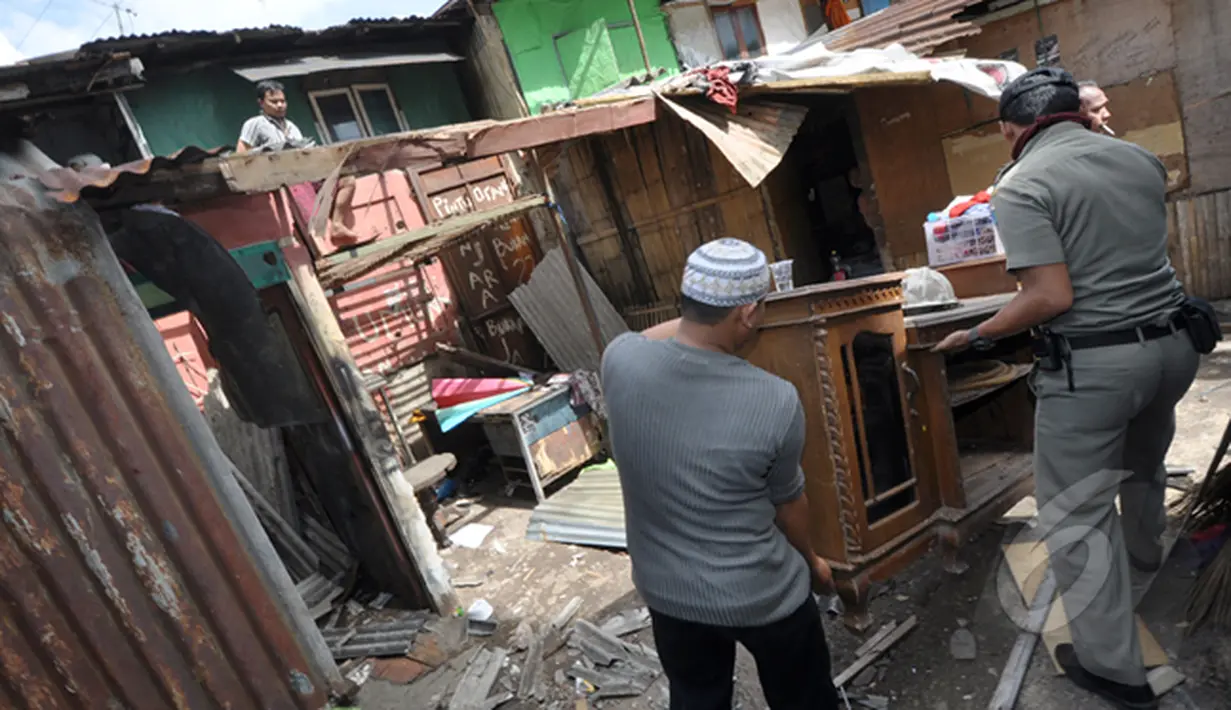 Seorang warga saat membawa barang miliknya di kawasan rusun tanah tinggi, Jakarta, Rabu (4/3/2015).  Sebanyak 10 bangunan liar di Rumah Susun (Rusun) Tanah Tinggi ditertibkan aparat satpol PP. (Liputan6.com/Faizal Fanani)