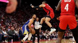 Pemain Golden State Warrirors, Stephen Curry (kiri) berusaha mengecoh pemain Houston Rockets, Dillon Brooks pada laga lanjutan NBA 2023/2024 di Toyota Center, Houston, Texas, 29 Oktober 2023 waktu setempat. (AFP/Getty Images/Tim Warner)
