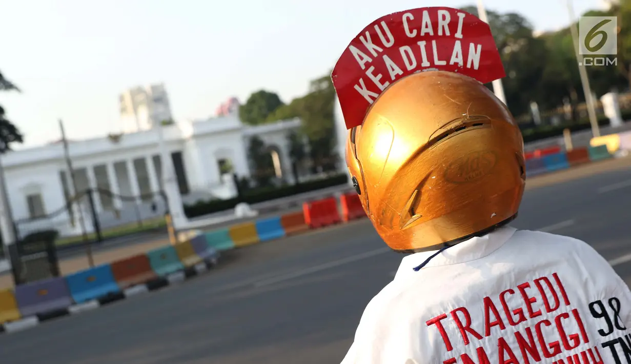Aktivis yang tergabung dalam Jaringan Solidaritas Korban untuk Keadilan menatap ke arah Istana Negara saat aksi Kamisan, Jakarta, Kamis (25/7/2019). Aksi Kamisan ke-594 mengangkat tema '23 Tahun Tragedi 27 Juli Saat Jadi Penguasa Kok Malah Tidak Peduli?'. (Liputan6.com/Helmi Fithriansyah)
