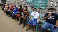 Warga antre untuk melakukan vaksinasi booster COVID-19 di Balai RW 04, Ciganjur, Jakarta Selatan, Senin (18/7/2022). Pemerintah mulai memberlakukan kebijakan wajib vaksinasi ketiga atau booster COVID-19 sebagai syarat perjalanan dan masuk ke ruang publik mulai 17 Juli 2022. (merdeka.com/Arie Basuki)