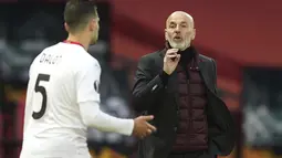 Pelatih AC Milan, Stefano Pioli menginstruksikan bek Diogo Dalot saat bertanding melawan Manchester United pada pertandingan leg pertama babak 16 besar Liga Europa di Old Trafford, Inggris, Jumat (12/3/2021). Hasil ini penting bagi AC Milan dalam format duel dua leg. (AP Photo/Dave Thompson)