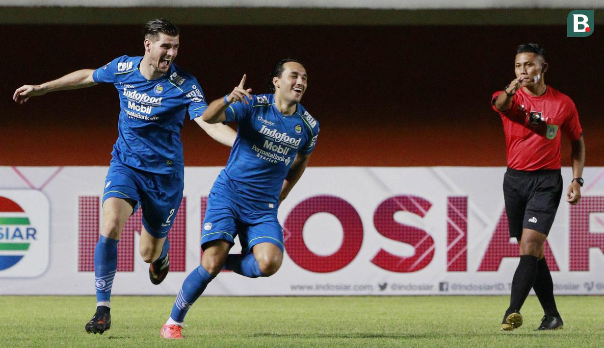 Striker Persib Bandung, Ezra Walian (kanan) melakukan selebrasi usai mencetak gol pertama timnya ke gawang Persebaya Surabaya dalam laga perempatfinal Piala Menpora 2021 di Stadion Maguwoharjo, Sleman, Minggu (11/4/2021). (Bola.com/M Iqbal Ichsan)