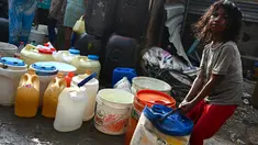 Seorang gadis menyeret ember berisi air yang dikumpulkan dari truk tangki air perusahaan kota di lingkungan berpenghasilan rendah di New Delhi pada Kamis (3/6/2021). Pada tahun 2018, lebih dari 600 juta orang di India tidak memiliki akses air bersih yang cukup. (Money SHARMA / AFP)