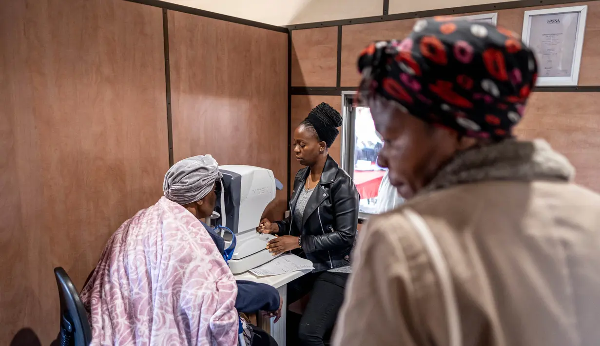 Seorang dokter mata melakukan pelayanan konsultasi di dalam kereta Phelophepa, yang diparkir di stasiun kereta Dube di Soweto, pada tanggal 17 Oktober 2023. (EMMANUEL CROSET/AFP)