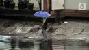 Pejalan kaki menggunakan payung saat hujan mengguyur Jakarta, Senin (26/10/2020). BPBD DKI Jakarta mengeluarkan peringatan dini cuaca berupa potensi terjadinya hujan lebat disertai petir dan angin kencang dampak dari siklon tropis Molave hingga 27 Oktober 2020. (merdeka.com/Iqbal S. Nugroho)