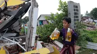 Seorang anak melintas di samping bangunan yang roboh akibat gempa di Kampung Kadudampit, Kabupaten Cianjur, Jawa Barat, Selasa (22/11/2022. Data dari BPBD Kabupaten Cianjur mencatat, hingga pukul 21.30 WIB sebanyak 162 orang meninggal dunia, 326 warga luka-luka, dan 13.784 warga mengungsi. (Liputan6.com/Herman Zakharia)