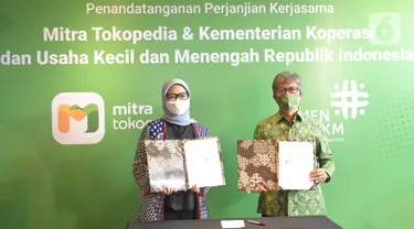 (ki-ka) Direktur Kebijakan Publik dan Hubungan Pemerintah Tokopedia Astri Wahyuni dan Deputi Bidang Usaha Mikro Kemenkop dan UKM Eddy Satriya menunjukkan perjanjian kerja sama pembinaan dan pemberdayaan pelaku usaha mikro dalam program Digitalisasi Warung di Jakarta (3/11/2021) (Liputan6.com/HO/ID)