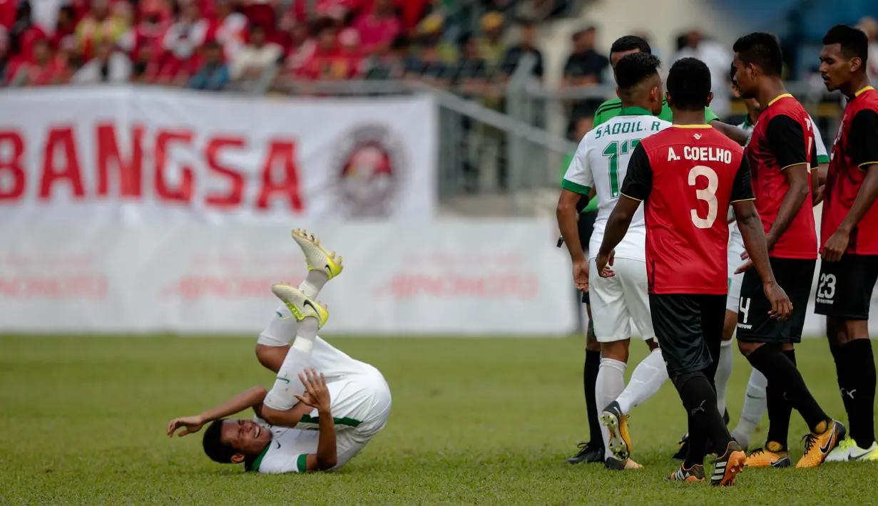 Evan Dimas terjatuh saat kericuhan terjadi pada laga ketiga Grup B SEA Games 2017 antara Timor Leste melawan timnas Indonesia U-22 di Selayang Stadium, Minggu (20/8/2017). (Liputan6.com/Faizal Fanani)