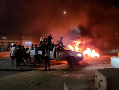 Warga Libya membakar ban saat mereka melakukan protes setelah Menteri Luar Negeri Najla Mangoush bertemu secara informal dengan Menlu Israel, di Tripoli, Senin (28/8/2023). (Photo by Mahmud TURKIA / AFP)