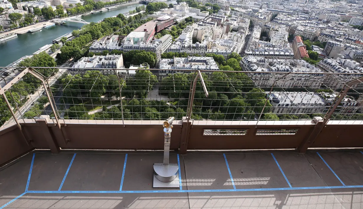 Tanda yang mengingatkan para wisatawan untuk menjaga jarak sosial (social distancing) terlihat di Menara Eiffel, Paris, Prancis, Kamis (18/6/2020). Langkah-langkah sanitasi diterapkan guna memastikan keamanan para wisatawan. (Xinhua/Gao Jing)