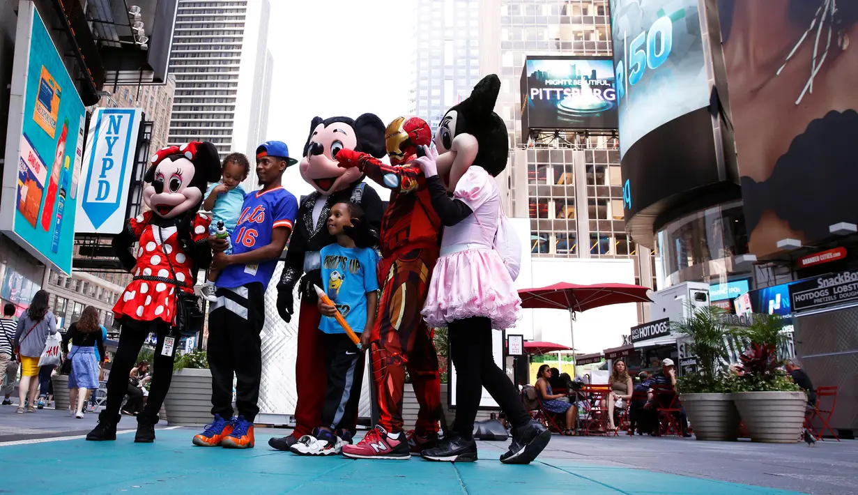 Seorang pengunjung berfoto bersama sejumlah karakter kartun di Times Square, New York, Selasa (21/6). Kehadiran karakter-karakter kartun tersebut mengundang warga untuk foto bersama. (REUTERS/Lucas Jackson)