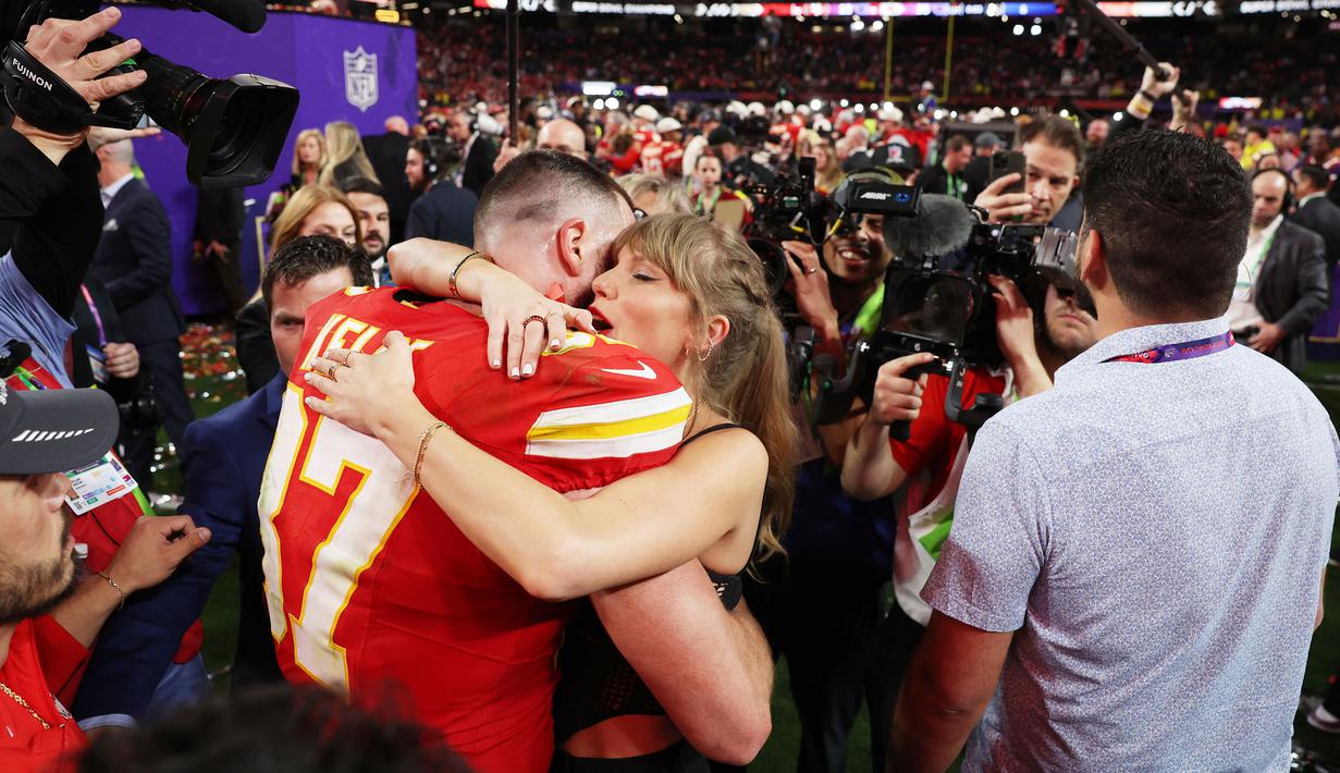Pemain Kansas City Chiefs, Travis Kelce (kiri) berpelukan dengan kekasihnya sekaligus penyanyi top dunia, Taylor Swift setelah memenangkan Super Bowls LVIII di Las Vegas, Amerika Serikat, Minggu (11/02/2024) waktu setempat. Kansas City Chiefs menang atas San Francisco 49ers dengan skor 25-22 melalui babak tambahan. (AP Photo/John Locher)
