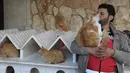 Mohammed Alaa al-Jaleel bermain dengan kucing di rumah Suaka Kucing Ernesto di Kfar Naha, Suriah (17/3). Karena kepeduliannya ini, Mohammed Alaa al-Jaleel mendapat julukan Cat Man of Aleppo. (AFP/Omar Haj Kadour)