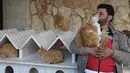 Mohammed Alaa al-Jaleel bermain dengan kucing di rumah Suaka Kucing Ernesto di Kfar Naha, Suriah (17/3). Karena kepeduliannya ini, Mohammed Alaa al-Jaleel mendapat julukan Cat Man of Aleppo. (AFP/Omar Haj Kadour)