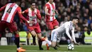 Gelandang Real Madrid, Marco Asensio, terjatuh saat berebut bola dengan bek Girona,  Pedro Alcala, pada laga La Liga di Stadion Santiago Bernabeu, Senin (19/3/2018). Real Madrid menang 6-3 atas Girona. (AFP/Javier Soriano)