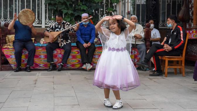 Seorang gadis kecil menari dengan iringan musik di Grand Bazaar Food Street di Urumqi, ibu kota Daerah Otonom Uighur Xinjiang, China barat laut, pada 4 Juli 2020. (Xinhua/Ding Lei)