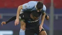 Bek Manchester City, Ruben Dias melompat untuk menyundul bola saat bersaing dengan penyerang Alassane Plea pada leg pertama 16 besar Liga Champions di Puskas Arena, Kamis (25/2/2021) dini hari WIB. Man City tekuk tuan rumah Borusia Monchengladbach 2-0. (AP Photo/Laszlo Balogh)