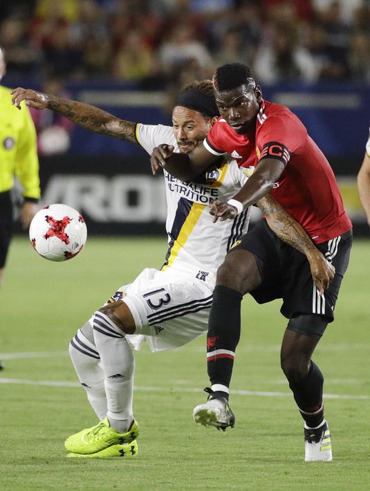 Duel pemain Manchester United, Paul Pogba (kanan) dan pemain LA Galaxy, Jermaine Jones pada laga persahabatan di StubHub Center, California, Sabtu (15/7/2017). MU menang 5-2. (AP/Jae C. Hong)