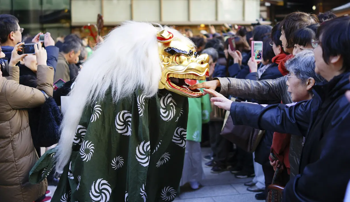 Penampilan tarian singa yang dikenal sebagai Shishimai selama Festival Konpira di kuil Kotohiragu di distrik bisnis Toranomon, Tokyo (10/1/2020). Orang-orang percaya tarian singa ini yang diadakan pada musim Hari Tahun Baru, membawa keberuntungan dan mengusir kejahatan. (AP Photo/Eugene Hoshiko)