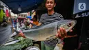 Pedagang menunjukkan ikan bandeng di kawasan Rawa Belong, Jakarta  Barat, Jumat  (9/2/2024). (Liputan6.com/Angga Yuniar)