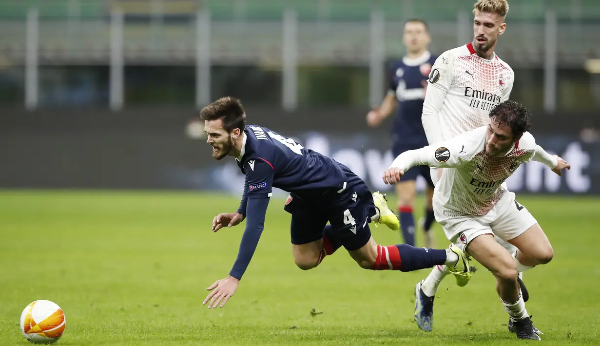 Gelandang Red Star Belgrade, Mirko Ivanic (kiri) terjatuh usai perebutan bola dengan striker AC Milan, Samu Castillejo dalam laga leg kedua babak 32 Besar Liga Europa 2020/21 di San Siro Stadium, Kamis (25/2/2021). Red Star Belgrade bermain Imbang 1-1 dengan AC Milan. (AP/Antonio Calanni)