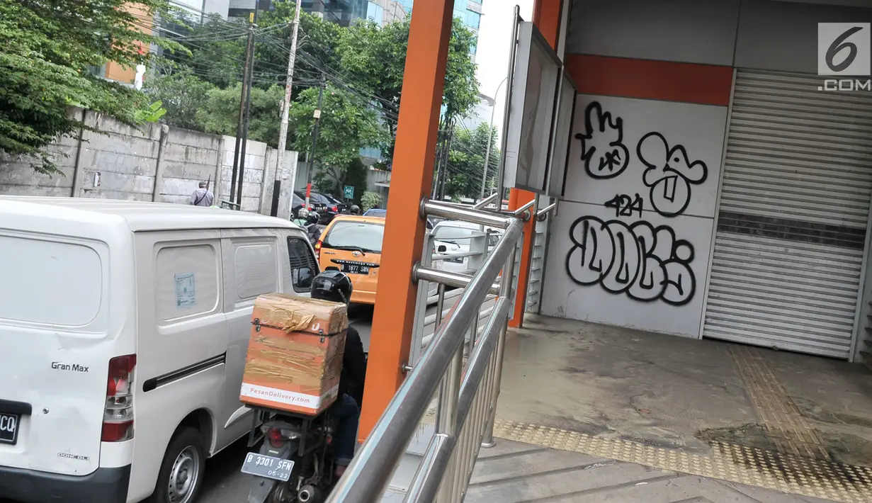 Coretan dengan cat semprot di bagian pintu masuk Halte Transjakarta Koridor 13, di Tendean, Jakarta, Senin (10/7). Coretan tersebut mengotori dan menimbulkan kesan kumuh serta tidak terawat. (Liputan6.com/Yoppy Renato)