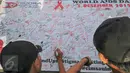 Sejumlah warga menandatangani petisi Peduli HIV/AIDS di kawasan Bundaran HI saat Car Free Day, Jakarta, Minggu (13/12/2015). Kegiatan tersebut dalam rangka memperingati hari AIDS sedunia. (Liputan6.com/Yoppy Renato)