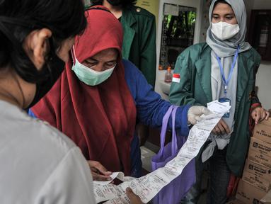 Warga menukarkan struk pembelian dengan bahan pangan saat pendistribusian Program Pangan Bersubsidi di RPTRA Permata Intan,Jakarta, Rabu (9/2/2022). Pemprov DKI kembali menggelar Program Pangan Bersubsidi yang terdiri atas beras, susu, daging, ikan, dan telur. (merdeka.com/Iqbal S Nugroho)