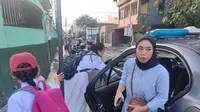 Para siswa di Garut, Jawa Barat, terlihat antusia menggunakan jemputan sekolah gratis yang diberikan anggota polisi, setelah jembatan yang biasa mereka gunakan terputus akibat banjir. (Liputan6.com/Jayadi Supriadin)